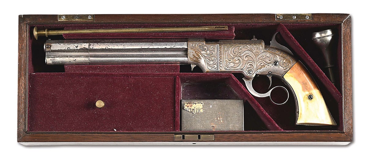 Cased deluxe engraved and fully-nickel-plated Volcanic Repeating Arms No. 2 Navy Model lever-action pistol manufactured circa 1856. Barrel marked ‘THE VOLCANIC / REPEATING ARMS CO. / PATENT NEW HAVEN CONN. FEB. 14, 1854.’ Reputedly featured in a 1957 issue of ‘The Gun Report.’ Very attractive gun in near-excellent condition with accessories.