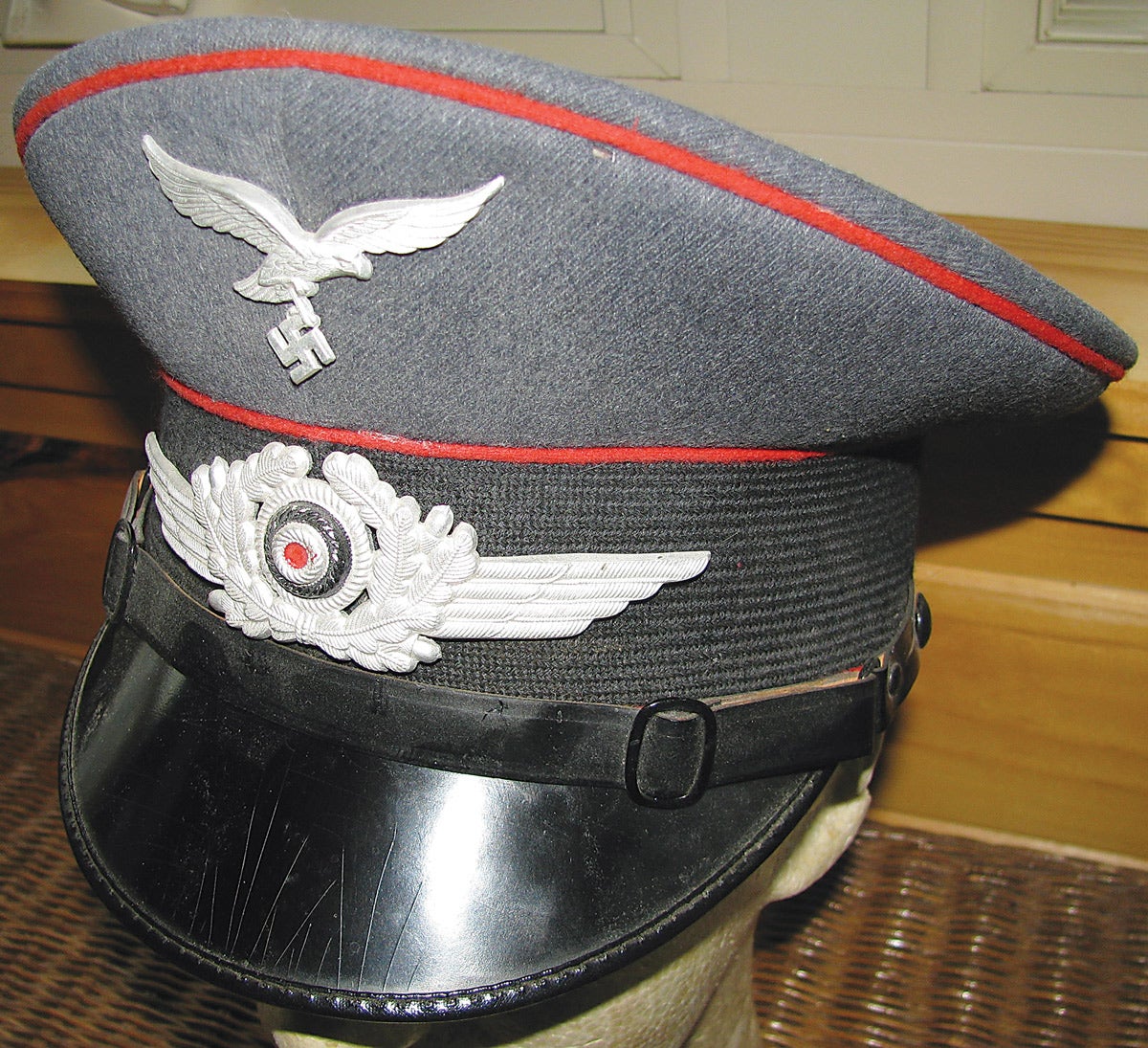 A standard issue Luftwaffe EM visor cap for flak personnel as designated by the red piping.