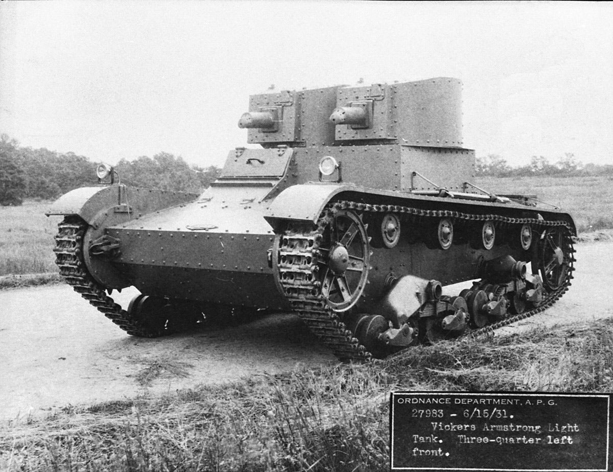 This front three-quarter view shows the front drive sprocket, track, track roller, truck rollers and suspension system.