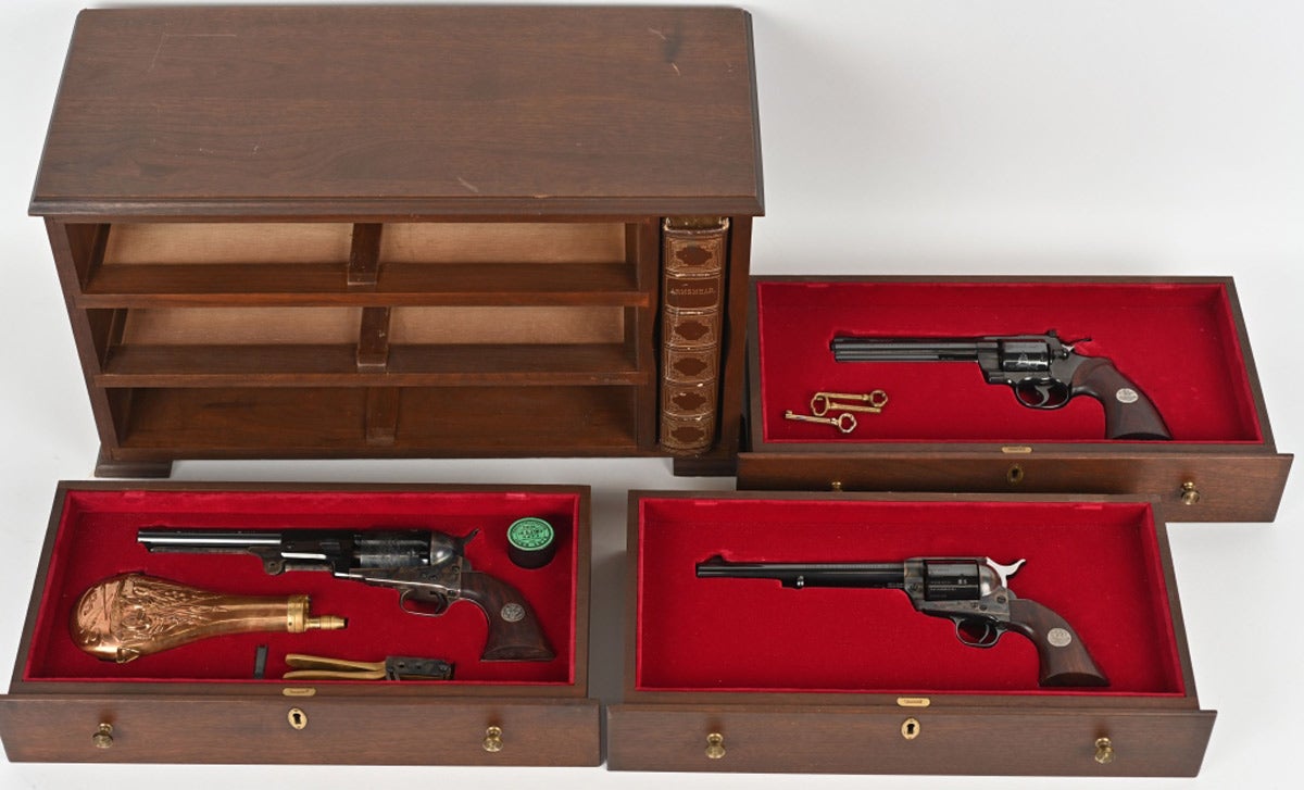Colt Bicentennial three-gun cased set consisting of a Colt Model 1848 Dragoon in .44 caliber percussion, Colt Single Action Army revolver in .45 caliber, and Colt Python in .357 Magnum caliber. All three in as-new condition with special 1776-1976 Bicentennial logo on the left side of their barrels and custom rosewood non-checkered grips with the Great Seal of the United States. Red-velvet-lined, French-fitted three-drawer walnut cabinet. One of 1,780 such sets produced in 1976. Sold at the midpoint of its estimate range for $7,897