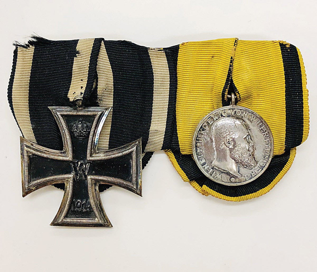 A Formal pairing of a 1914 
German Iron Cross in black and outlined in silver and 
a German 
Wuerttemberg Wilhelm II Merit Medal. 