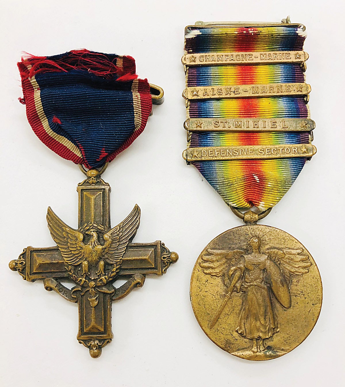 At left is one of the first 1000 DSC’s issued. It’s numbered 373 on the bottom arm of the cross. Note the variety of campaign bars on his WWI Victory Medal (right).