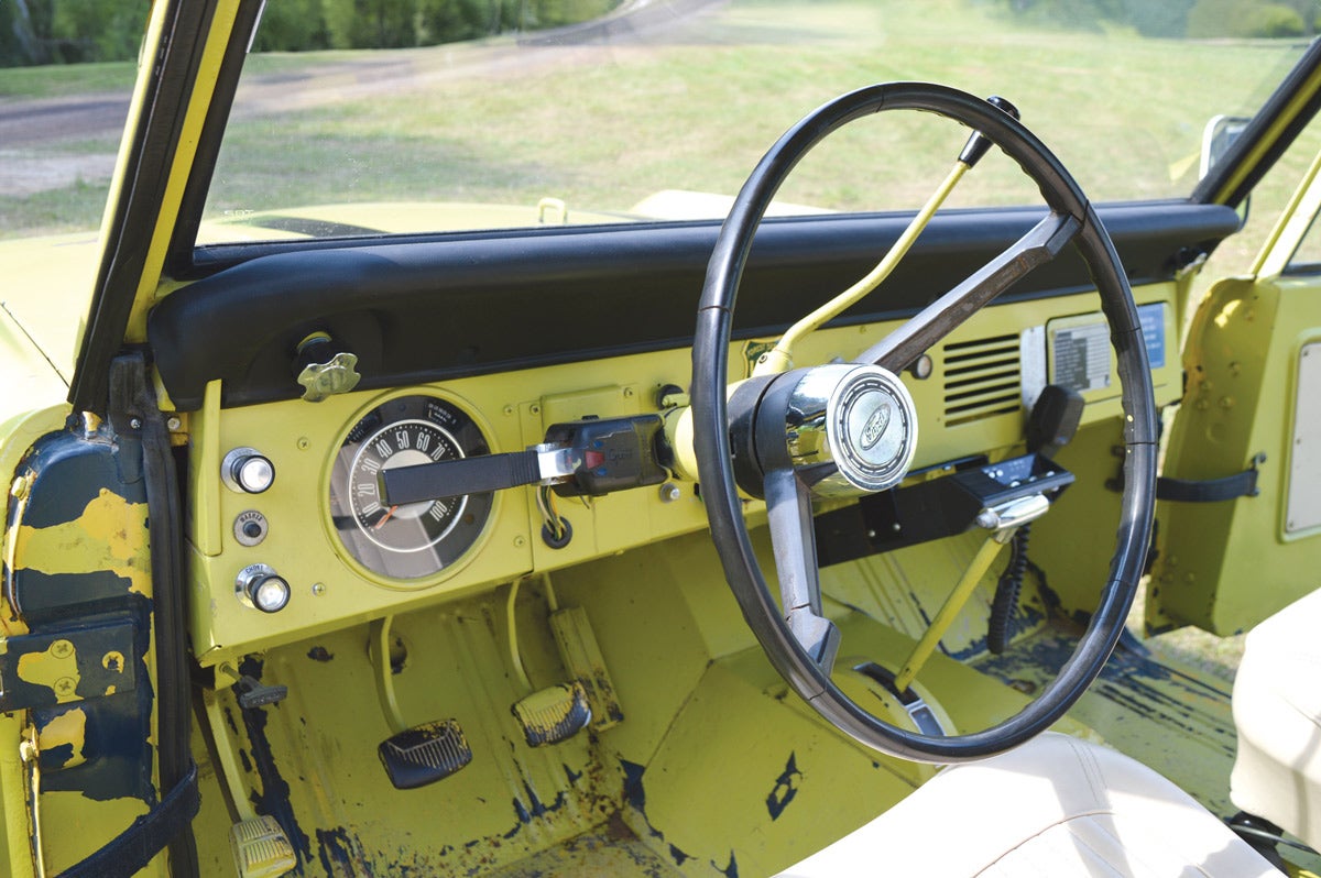 When the U.S. Forest Service received the Bronco from the military, it sprayed yellow paint everywhere — even on the pedals! Blue paint from the U.S. Air Force is visible where the yellow paint peeled in the door jambs and floor.