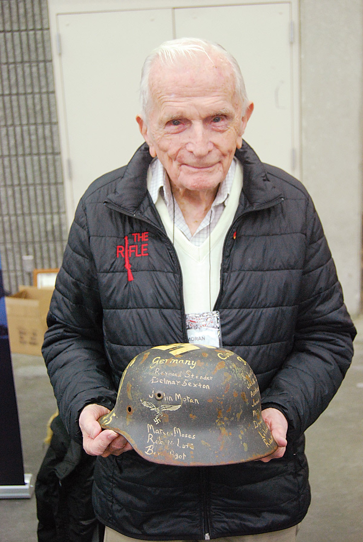 World War II veteran Jack Moran, who served with the U.S. Army’s Company K, 347th Infantry Regiment, 87th Infantry Division, and saw significant action during the Battle of the Bulge, holds a German helmet that he signed during the war, and then obtained decades later!