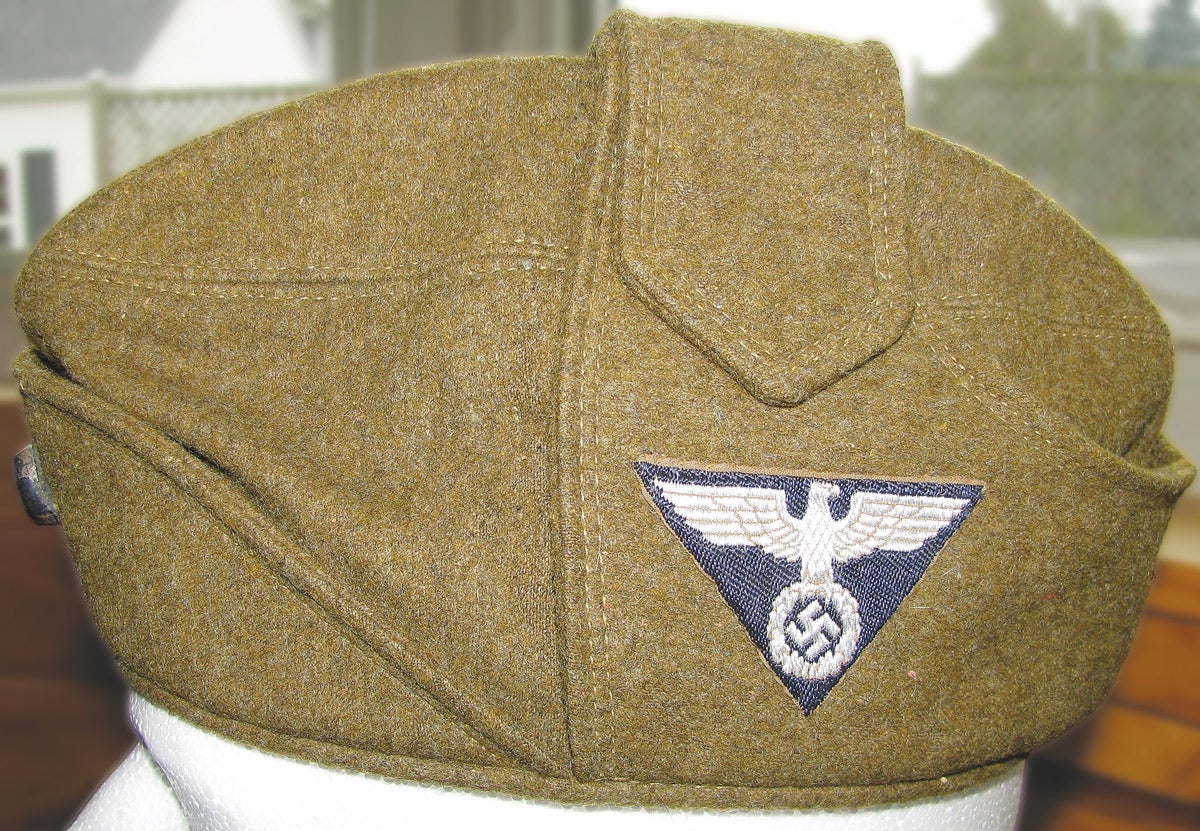 The distinctive SA-Wehrmannshaft wool cap with the earflaps buttoned together on the top. A black based eagle and swastika patch points to either Berlin-Brandenburg or Niederrhein as the SA Gruppe area.