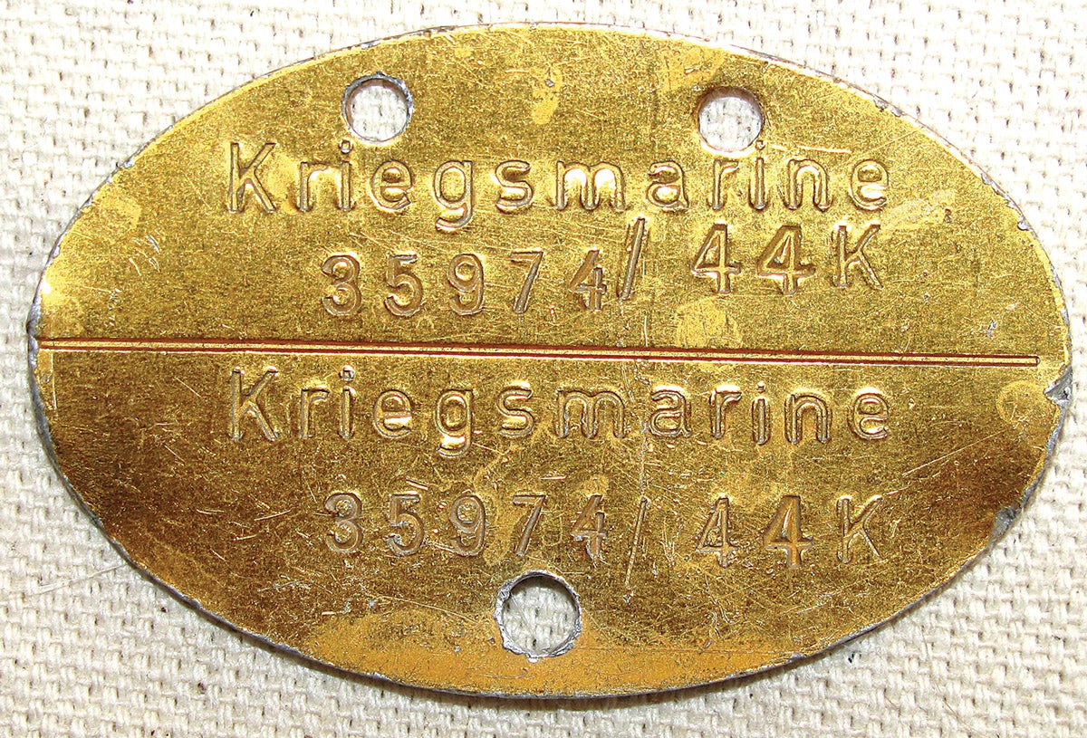 A standard “Kriegsmarine” Erkennungsmarke, smaller in size than those of the other services, and coated with a gold-colored layer.