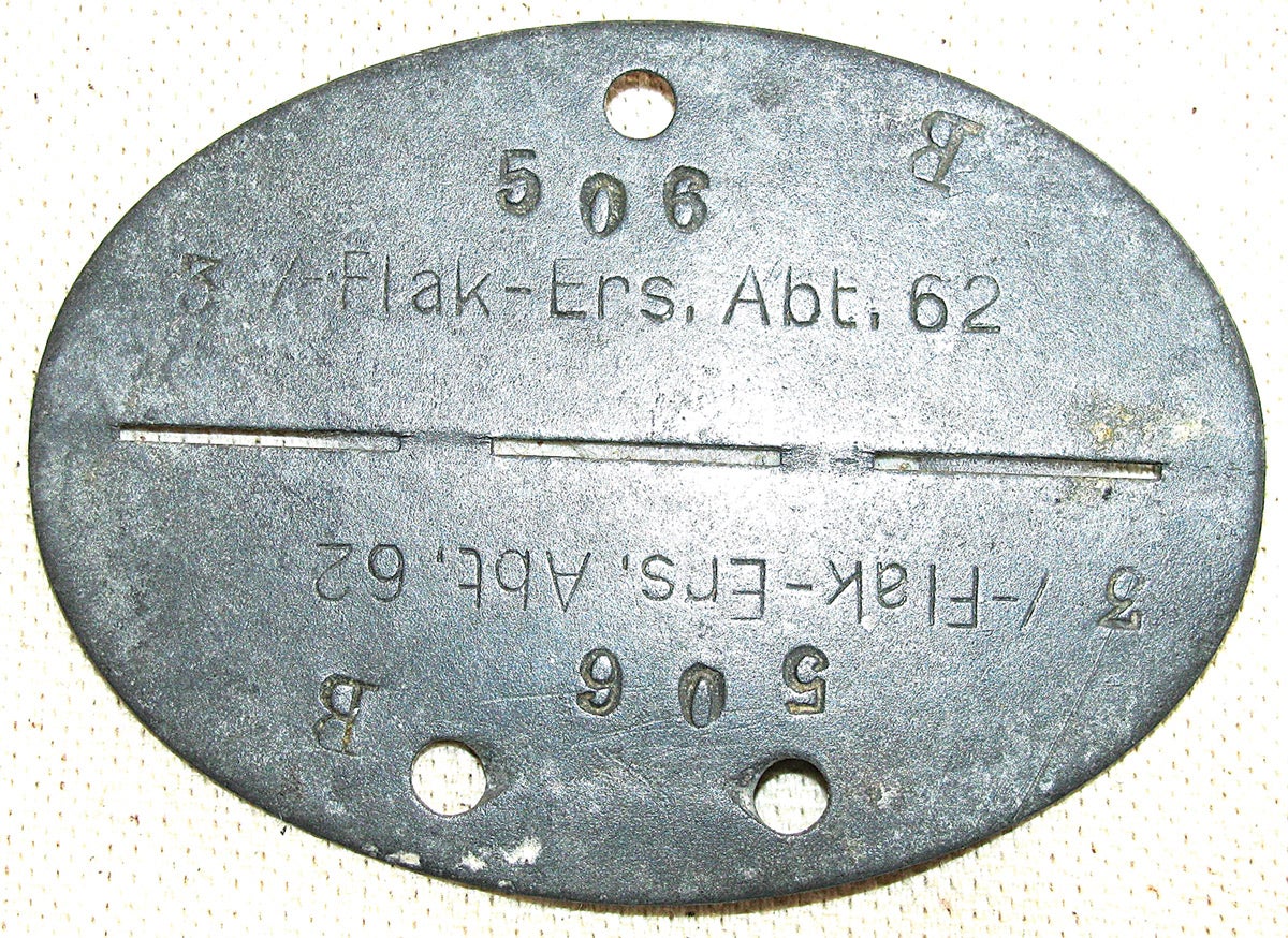 This Luftwaffe tag was issued to a replacement soldier in a Flak unit. The top and bottom are typed in a “mirrored fashion, making it more likely that the tag was not made in the battlefield, as the armorer took more time to stamp it out. The solder’s type “B” blood notation seems to have been haphazardly added later on.