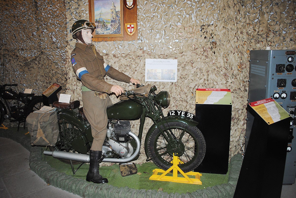 A Signaller dispatch rider astride a BSA M20 motorbike — as used during WWII — at the Signals Museum.