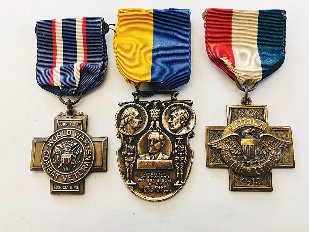 The far left and right four arm crosses carry the Whitehead & Hoag maker mark with the center medal attributed to the L.M Garfinkel Co. Columbus, Ohio.