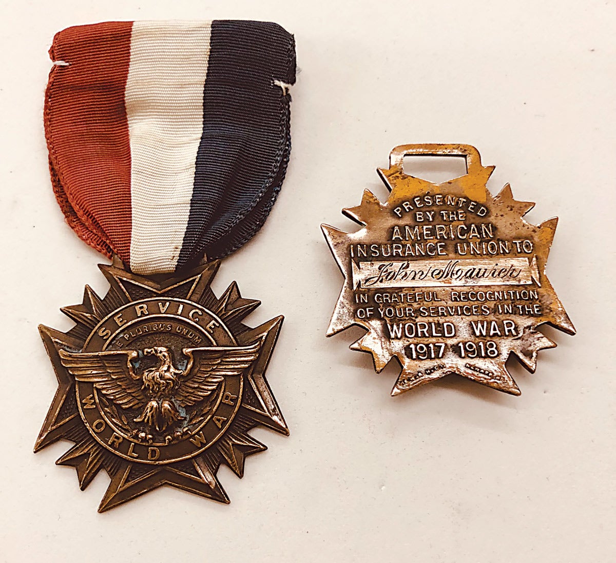 A striking Whitehead & Hoag Company WWI issue shows the obverse and reverse of one issued to employees of the American Insurance Union who served in the war.