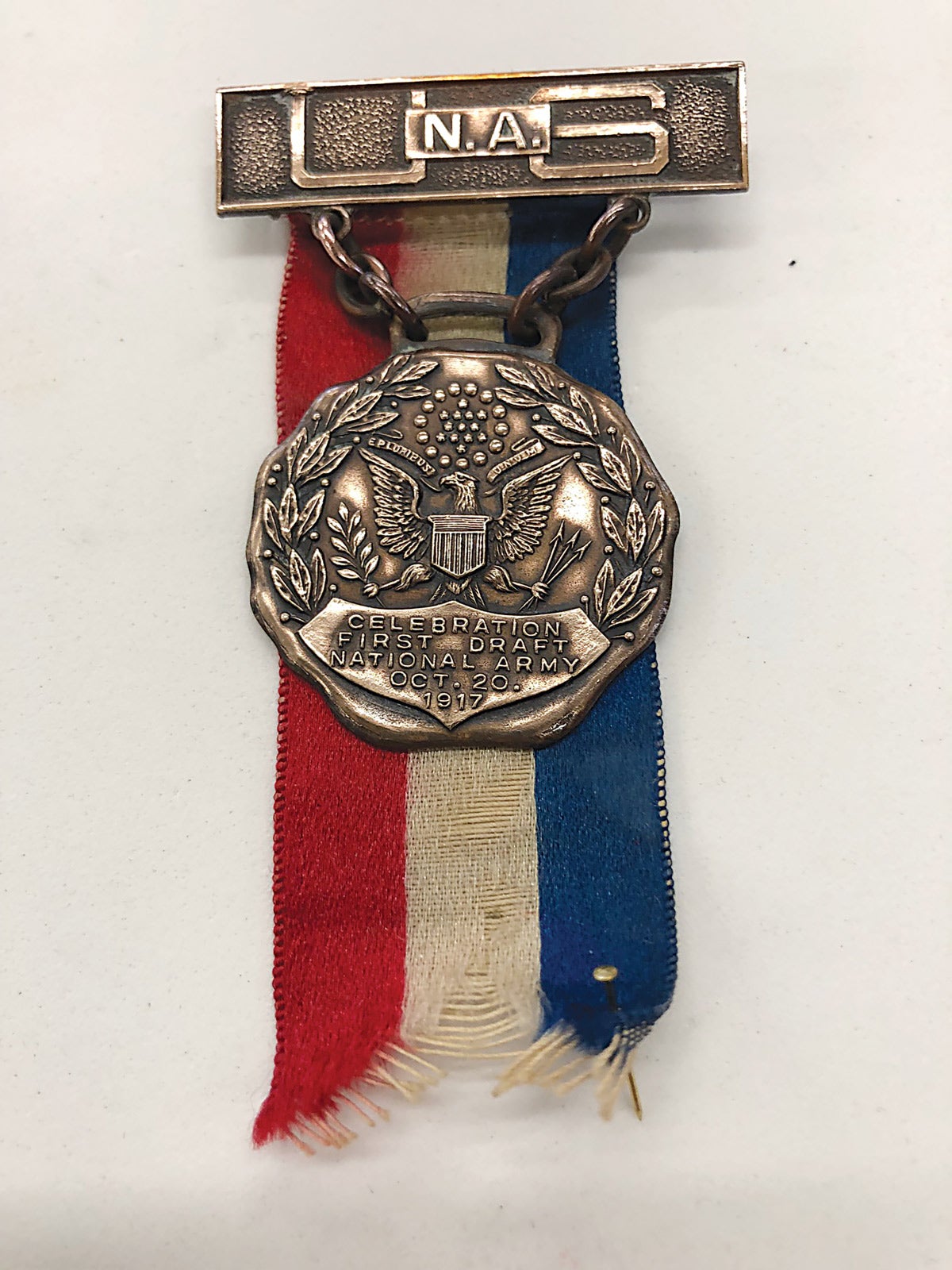 The National Army medal shows a reverse red, white, and blue drape and rectangular bronze brooch.