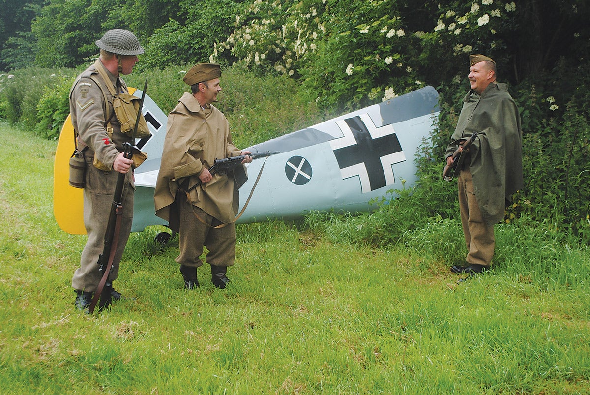 Re-enactors re-creating the role of guarding a German aircraft that has been shot down.