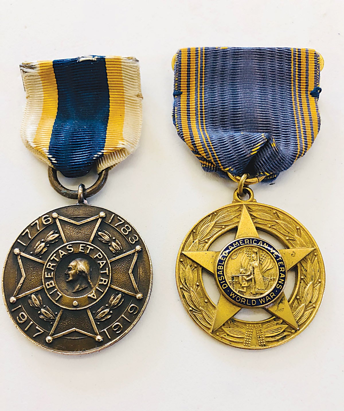 The center of the SAR medal carries a bust of George Washington and the center of the DAV WWI medal shows a kneeling soldier in front of Lady Victory.