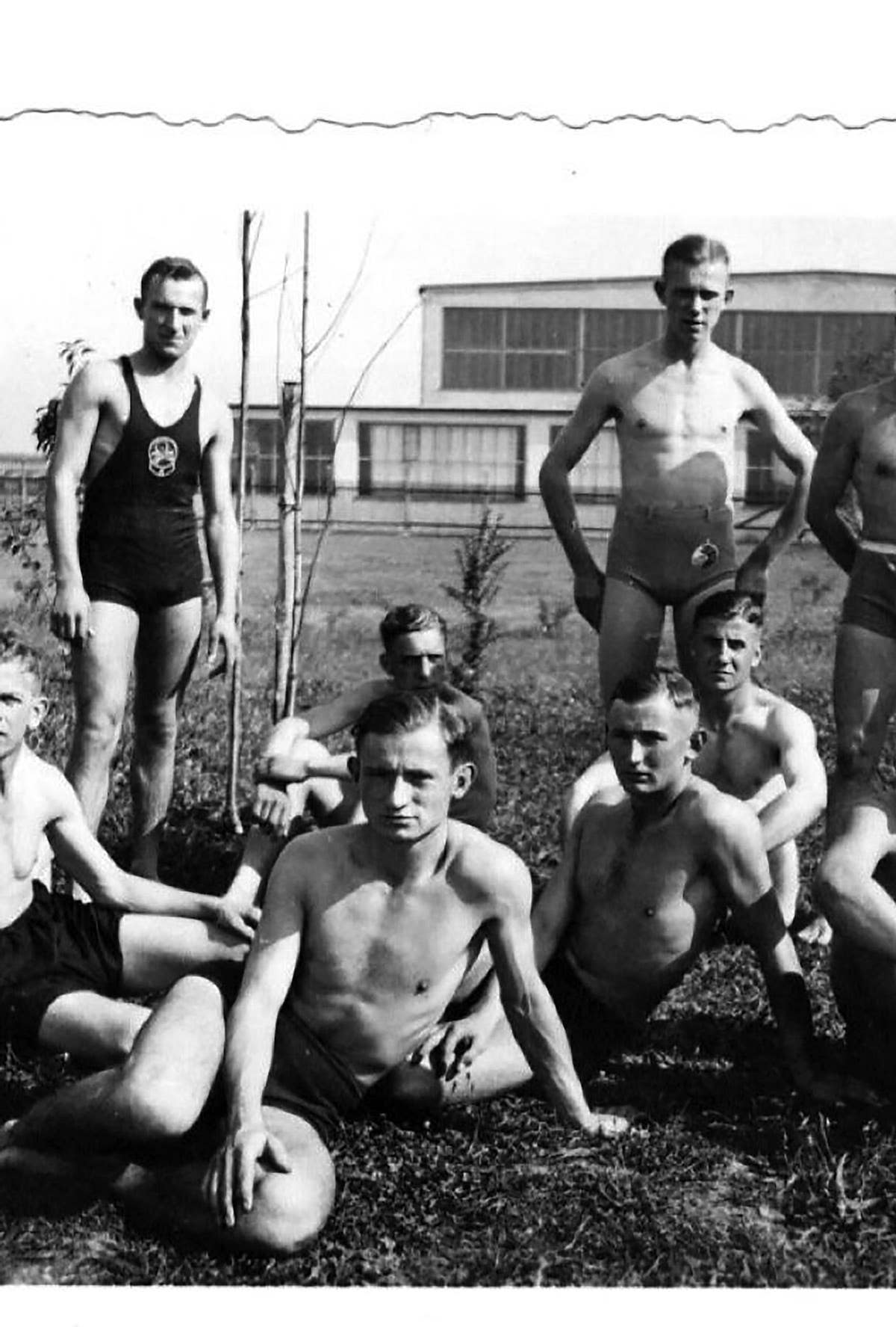 A group of German swimmers take time out for an informal group photo. The swimmer standing on the right wears a DLRG membership patch sewn to his swimming trunks.