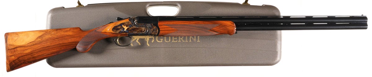 Caesar Guerini Magnus Jaspe 12 gauge over/under shotgun manufactured in 2007, Serial #11276, with single selective trigger and ejectors, 3in chambers with five interchangeable chokes and wrench. Gold game scene engraved, case colored receiver by Master Bottega Giovanelli. Varnished checkered pistol grip stocks with checkered wood butt plate. Very fine condition with 99% barrel finish and bright bores. Stocks very fine with some light handling and a scratch on left side of butt toward toe. Mechanically excellent. Comes in factory luggage case with chokes.