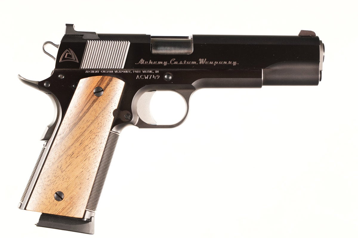 Alchemy Custom Prime Weaponry (Fort Wayne, Ind.) 9mm 1911 pistol with 5in barrel, Serial #ACW749. Blue finish with combat sights. Smooth walnut stocks. Skeletonized hammer with checkered front and back straps. Beavertail safety with match barrel. Excellent condition and mechanically excellent, with no indication of prior use. Comes with factory carry pouch with instructions and spare factory magazine. 
