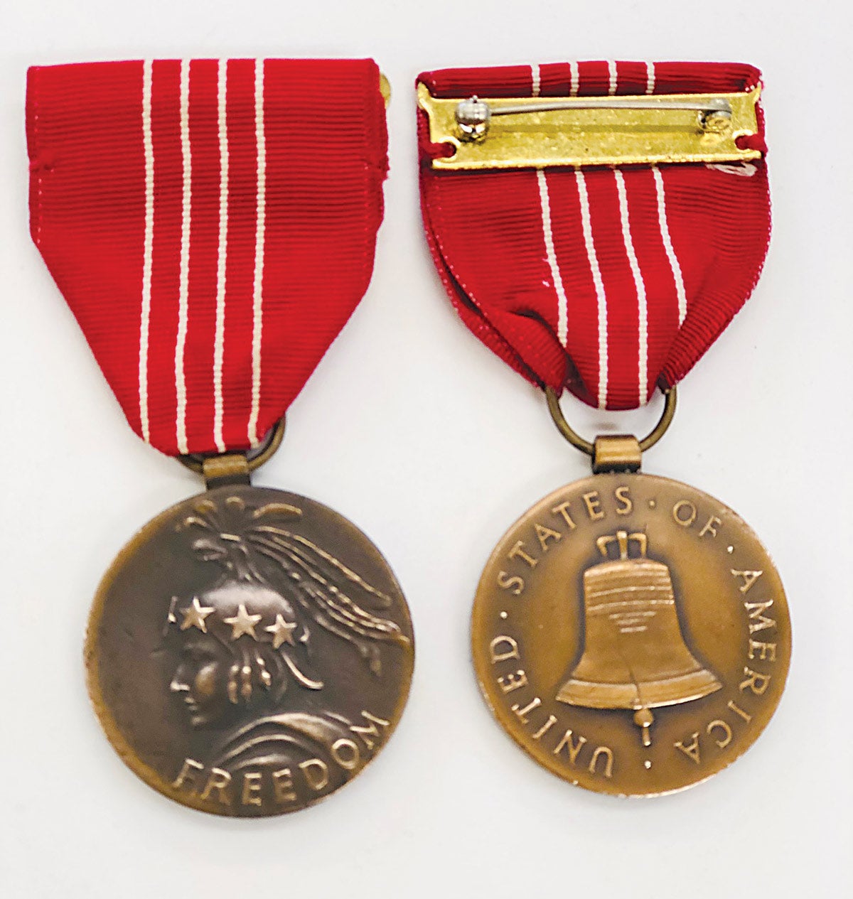 The obverse and reverse of the Medal of Freedom features both the bust of the Statue of Freedom and the Liberty Bell on the reverse with a slot brooch.