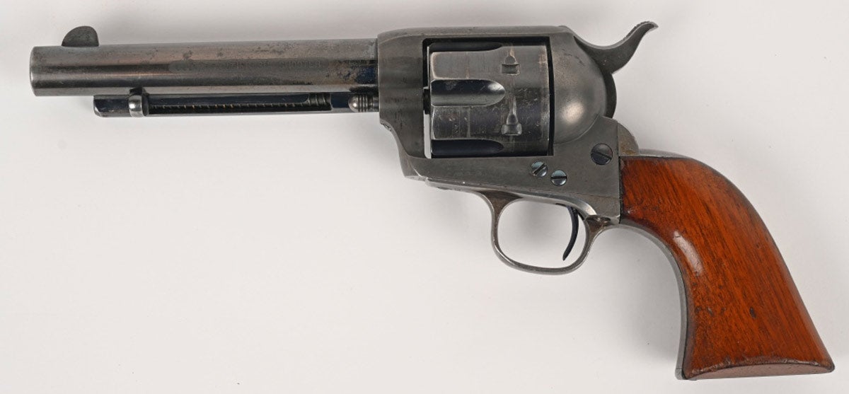 44-40 Colt Single Action Army Revolver manufactured in 1884 and acid-etched ‘COLT FRONTIER SIX SHOOTER’ on the left side of the frame. Blue-finished with one-piece walnut grips. Rare black-powder frame of a type generally set aside for use in building Cavalry revolvers. Government-inspected by David Clark; bottom of frame marked ‘D.F.C.’ Bottom breech of barrel marked ‘.44.’ Correct single-line barrel address. Fine condition with 60-75% original blue on barrel and cylinder. Excellent grips showing little wear and most of the original varnish. Tight action. Fine bore with light scattered abrasion.