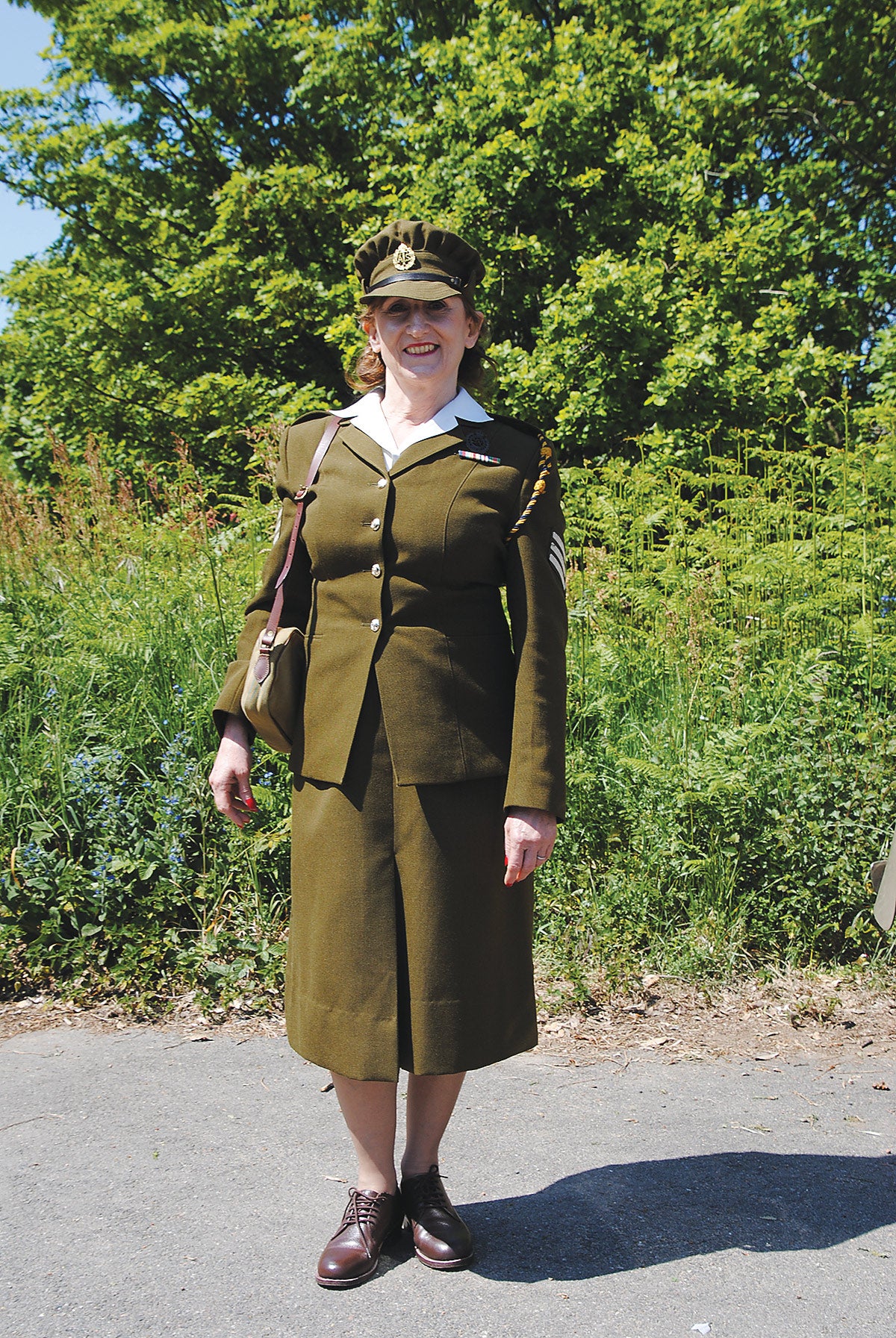 A very smart Auxiliary Territorial Service (ATS) sergeant adds a touch of glamor among all the green.