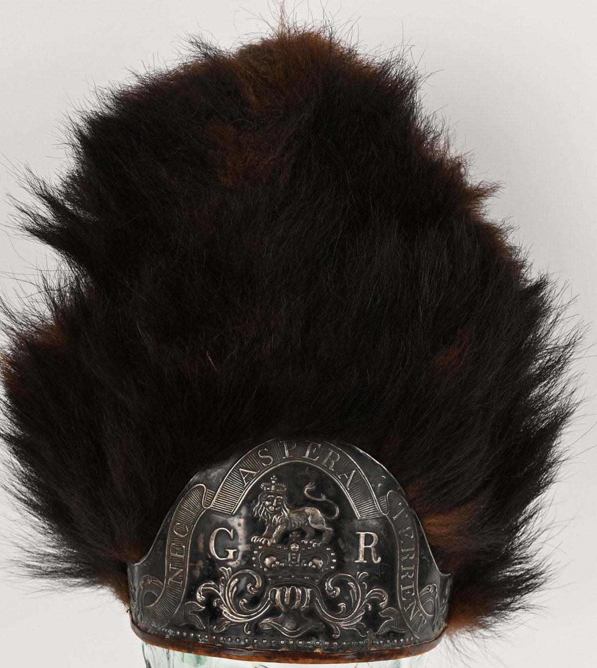Revolutionary War British grenadier’s fur mitre cap. Front plate adorned by beautiful scrollwork and royal crest flanked by ‘G R’ and the Latin motto ‘NEC ASPERA TERRENT’ (Difficulties be damned). Interior cloth liner shows staining and wear consistent with its age, but in excellent condition nonetheless.