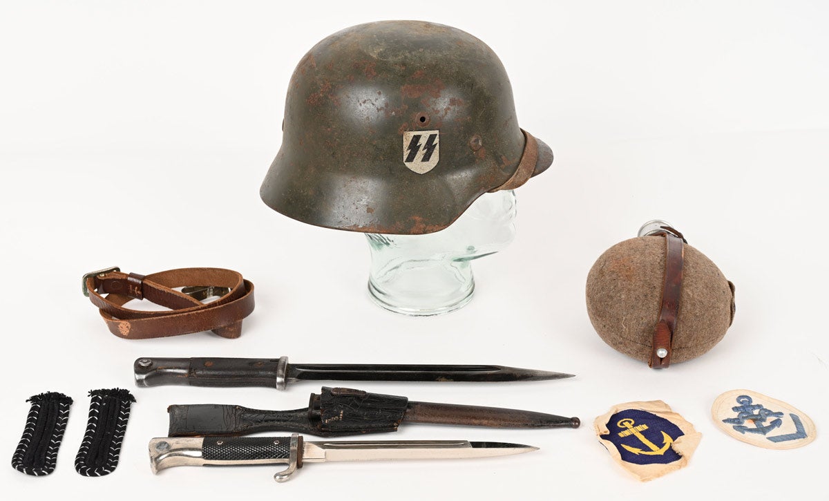 World War II Nazi German Waffen SS M35 double-decal helmet with ‘bring back’ paper. Grouping consists of helmet with SS runic and party shield decal with 95% paint retention, intact rivets, serial number, original M31 tan leather liner and chinstrap. Lot also includes German bayonets, canteen and insignia. All items were brought home to the US by Paul E Saurena, including the bring back paper.