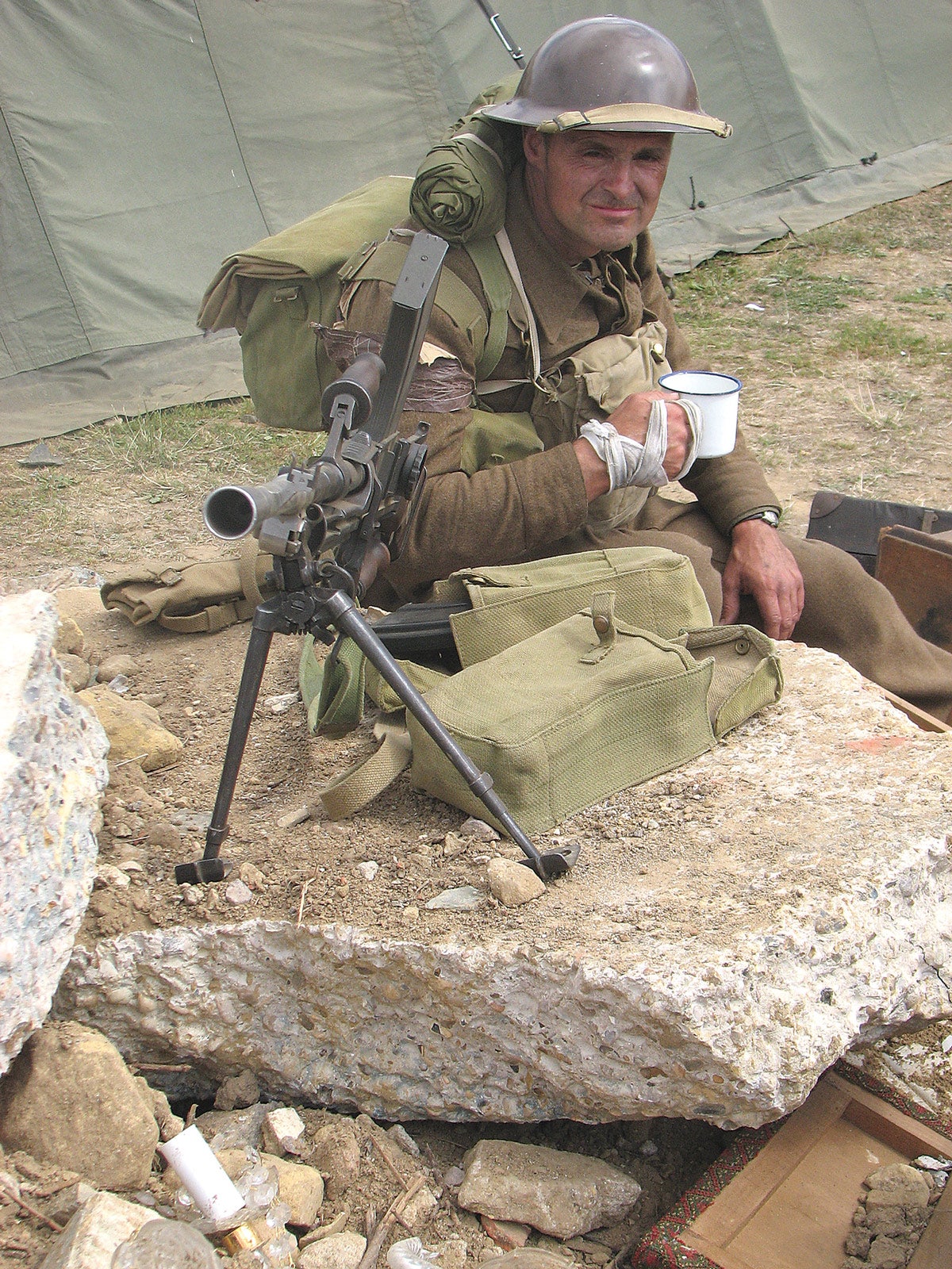 A re-enactor recreating a scene from Dunkirk, complete with Bren gun and mug of tea.