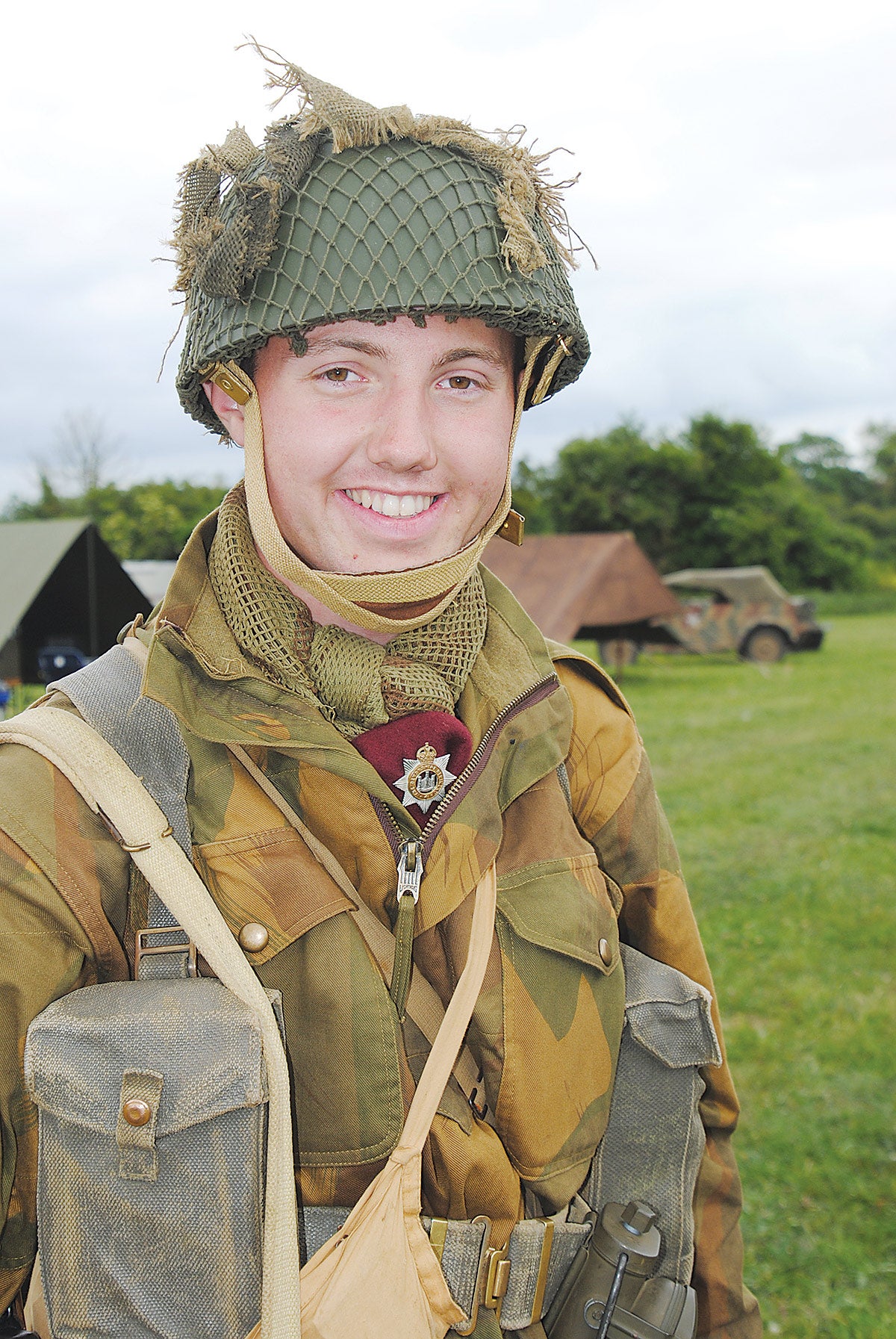 A smiling re-enactor depicting a British paratrooper counterpart to the 101st Airborne, looking as though he could be ready to take part in Operation Market Garden at Arnhem.