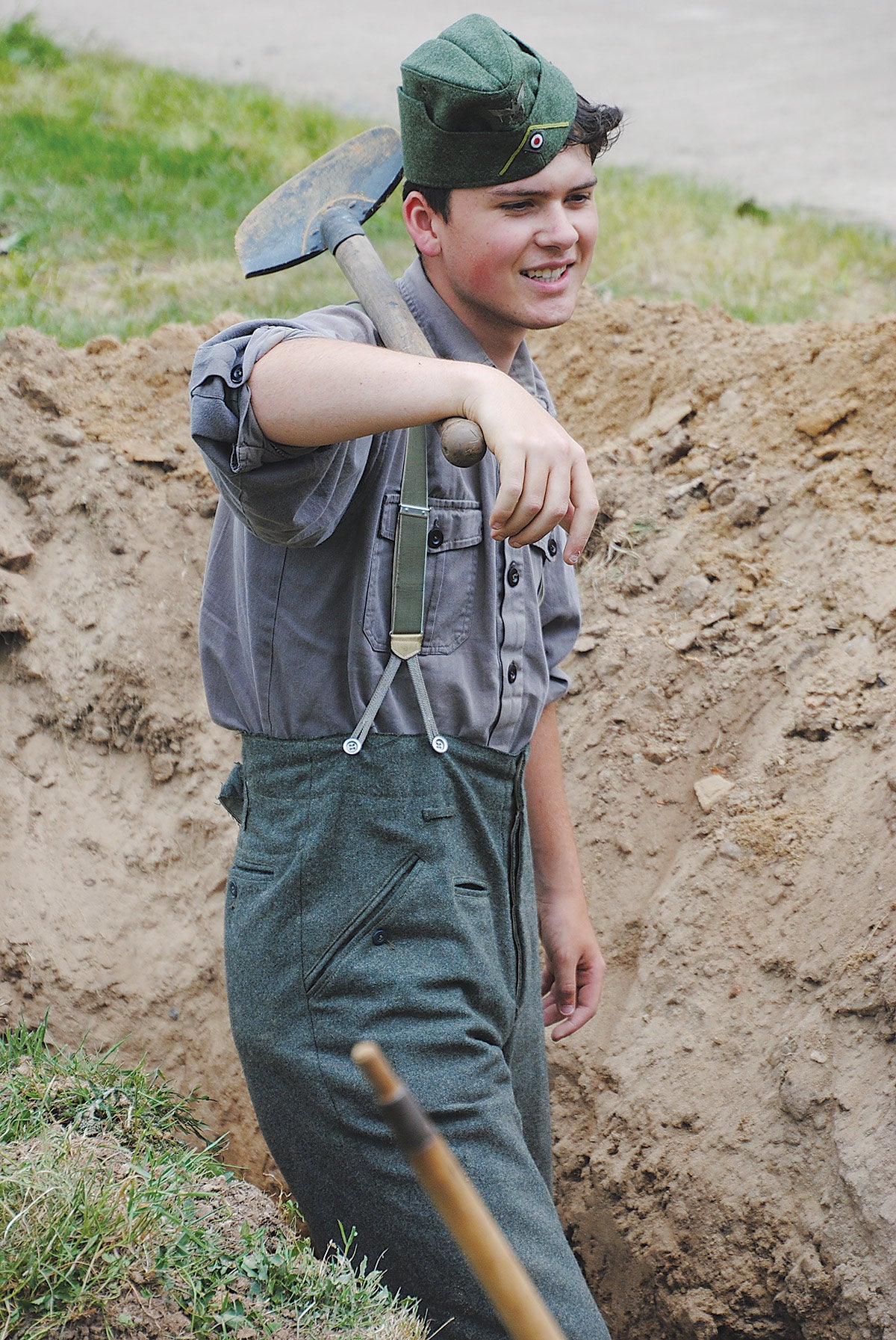 This young re-enactor is takes a well-deserved break from digging a slit trench using an authentic spade of the period.