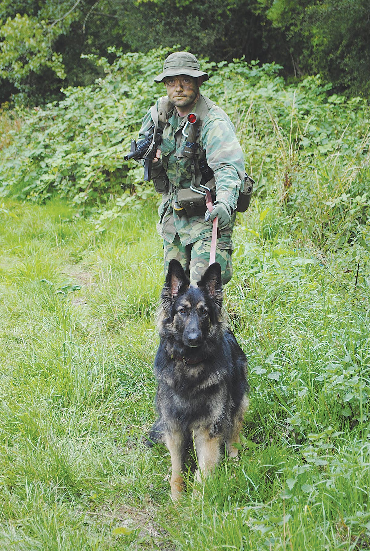 A re-enactor depicts a patrol in Vietnam with his loyal German shepherd. Canines are frequent visitors and participants these days at military living history events.
