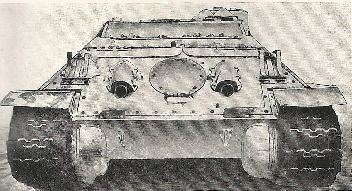 An illustration from a technical manual shows twin exhaust outlets and circular plate for access to engine for field service and maintenance.