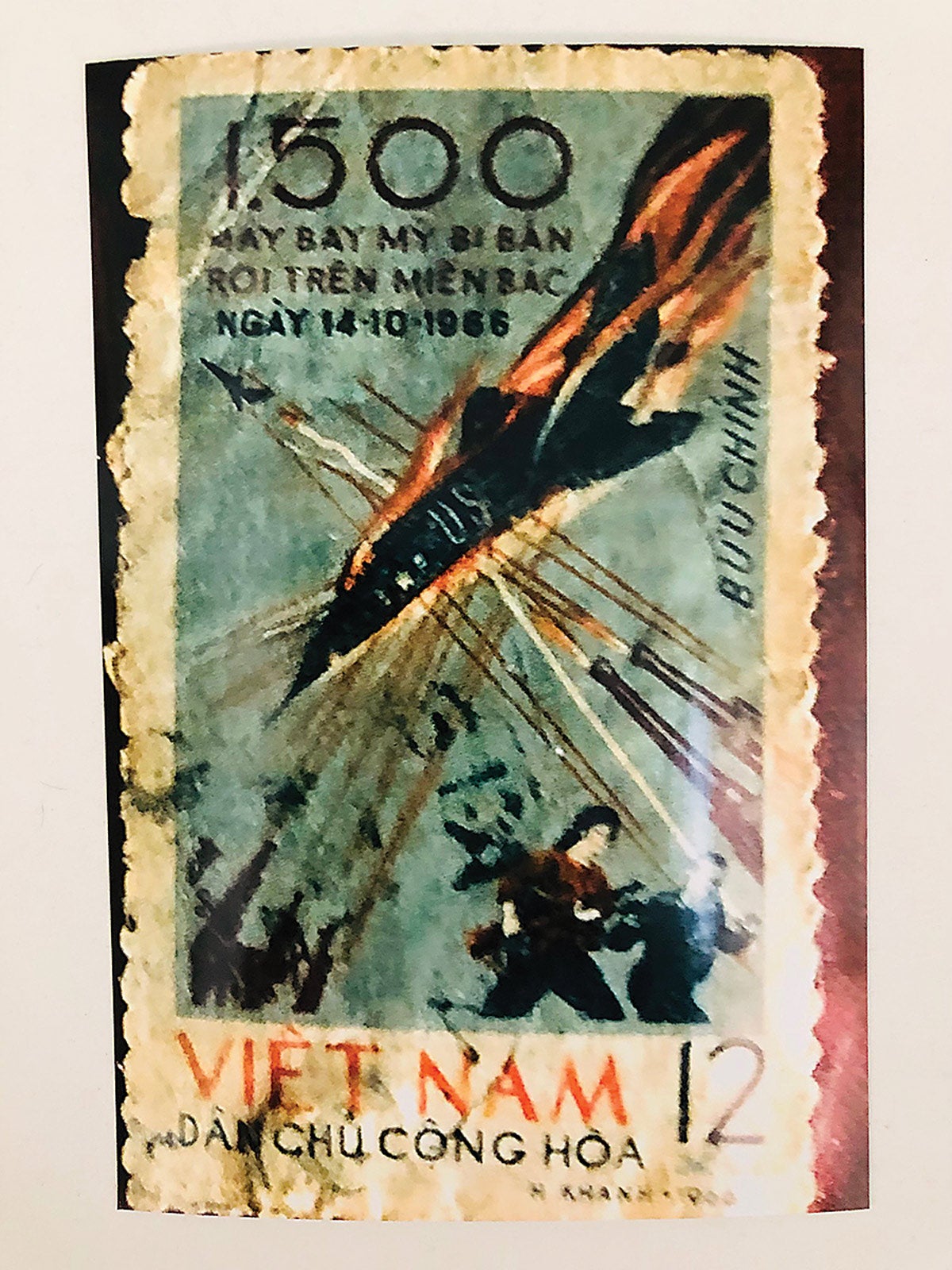 A close-up view of a North Vietnam wartime stamp showing the downing of a U.S. fighter.