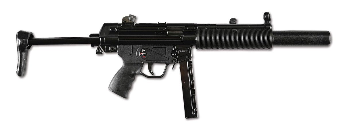 Factory-original 3-position ‘S.E.F.’ selector Heckler & Koch MP5SD3 registered-receiver machine gun manufactured in 1984 according to ‘IE’ proof code on top of receiver. Marked ‘Made in W. Germany / HK Chantilly, Va’ on right side of magazine well, and ‘HK MP5 SD’ on top of receiver. Caliber: 9mm Luger. Barrel length: 5.73in. Currently fitted with telescoping stock and immediately recognizable screw-on factory silencer. Also includes original fixed shoulder stock, four original straight ‘MP5 HK’ marked magazines dated ‘11/67,’ one ‘ID’ marked 20-round magazine, three-cell magazine pouch, and original H&K sight adjustment tool. NFA item requiring BATF approval prior to transfer to new owner.