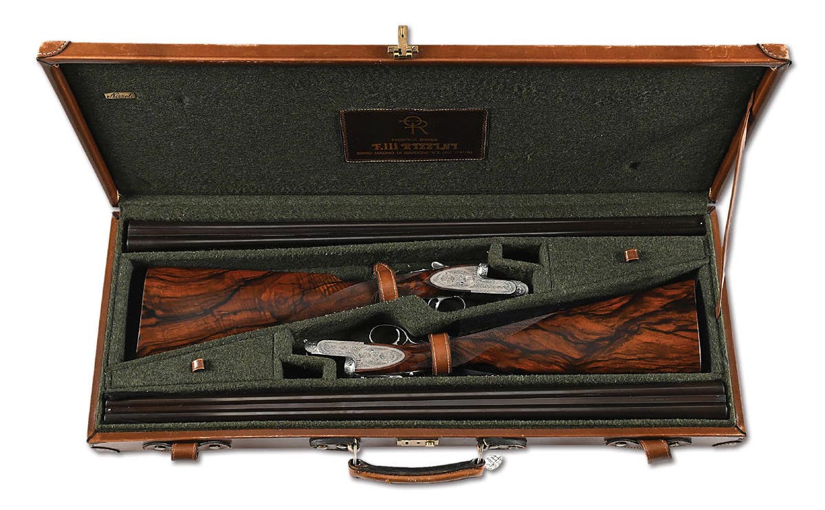 Fabulous pair of Rizzini R1 .410 (choked, modified and improved modified) and 28-gauge (choked improved cylinder and modified) side-by-side shotguns with 23-3/8in barrels and magnificent Angelo Galeazzi engravings of mourning doves and ducks, rose-and-scroll motif, etc. Both guns proofed in 1982, the .410 gun bearing Italian superior proof marks with 3in chambers and the 28-bore gun displaying Italian standard proof marks with 2¾in chambers. Highly-figured exhibition-grade walnut stocks. Incredible small-bore set in very high original condition, housed in a Nizzoli felt-lined leather case.