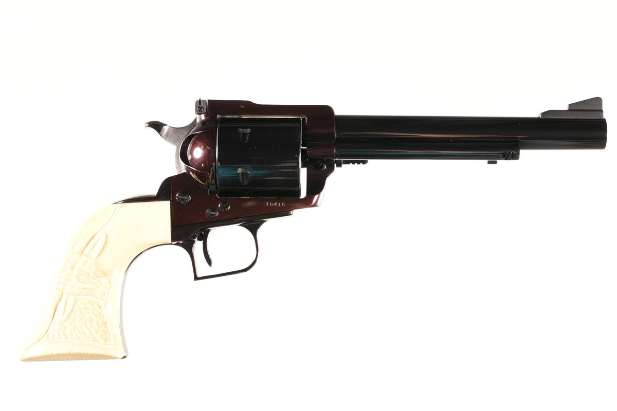 Customized Ruger Old Model Super Blackhawk .44 Magnum Revolver, Serial #10416, cut (or original?) to 6½ in barrel, high-polish blue. Rear sight, ejector knob and wide hammer spur all finely checkered. Finely-tuned action has NOT been converted to Transfer Bar System. Genuine ivory grips carved with steer head on right and large eagle head on left. Excellent condition. Provenance: Mike Stewart collection.