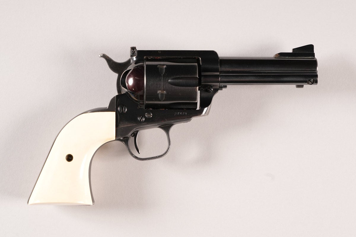 Customized Ruger Old Model Blackhawk Flat-Top .44 Magnum Revolver, Serial #27478, 4in barrel, high-polish blue. Checkered rear sight with rounded corners. Checkered hammer spur. Very nice tuned action has NOT been converted to Transfer Bar System. Gorgeous genuine ivory grips have a thick contour. Very Good condition with minor dings and scratches on grip frame. Provenance: Mike Stewart Collection.